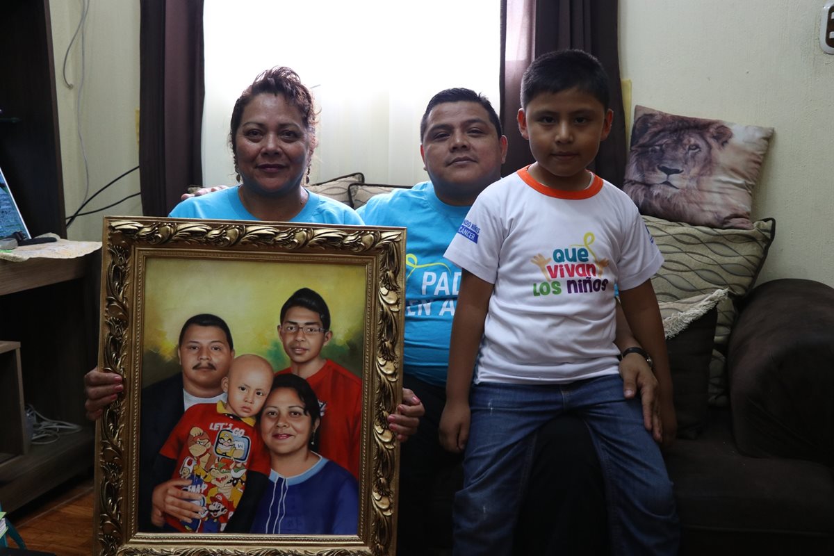La familia Punay Rivera, muestran la fotografía de su hijo que logró sobrevivir al cáncer.(Foto Prensa Libre: María José Longo.)