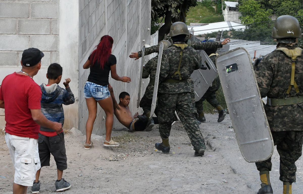 Soldados intentan arrestar a un manifestante, este sábado, cuando opositores volvieron a salir a las calles en protesta por las pasadas elecciones en Honduras. (Foto Prensa Libre: AFP)
