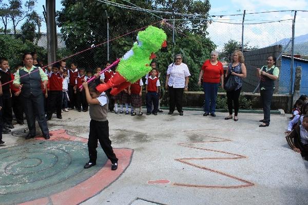 Niños quiebran piñata en   la escuela del cantón Santa Cruz, San Vicente Pacaya, Escuintla.