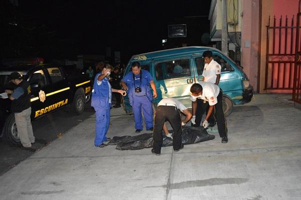 Socorristas cubren el cadáver de Sotero Acabal, quien murió baleado en Puerto San José. (Foto Prensa Libre: Enrique Paredes)