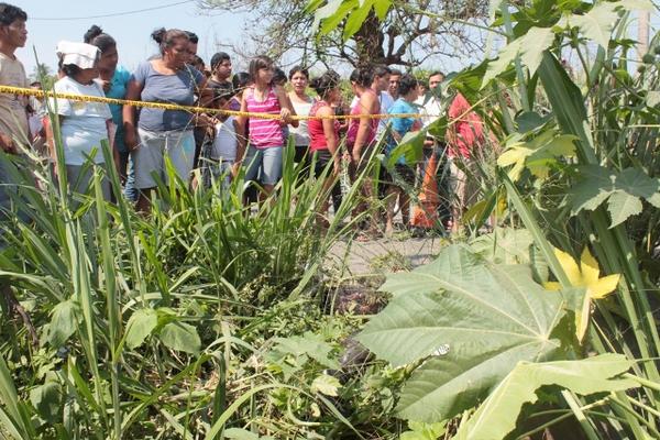 Curiosos observan el lugar donde fue hallado el cuerpo de un hombre, en Escuintla. (Foto Prensa Libre: Melvin Sandoval)<br _mce_bogus="1"/>