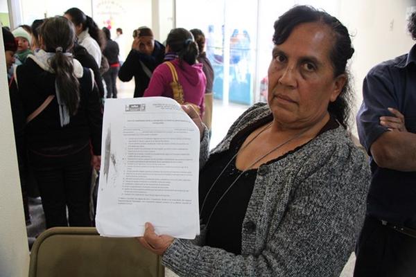 Una de las trabajadoras por contrato del Hospital Nacional de Totonicapán muestan el documento donde se les prohibe manifestar. (Foto Prensa Libre: Edgar Domínguez)