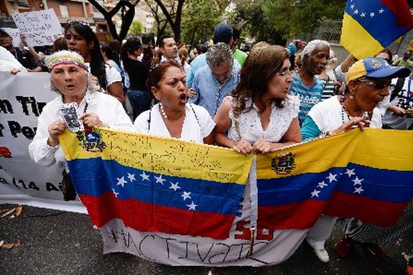 Activistas de la oposión marchan en protesta por la muerte de un joven estudiante en Venezuela. (Foto Prensa Libre: AFP)