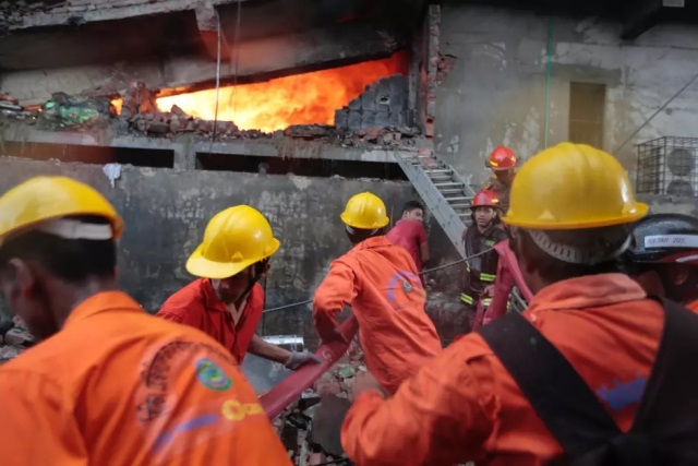 Bomberos trabajan para controlar las llamas en una fábrica de embalajes en la zona industrial de Tongi. (Foto Prensa Libre: AP)