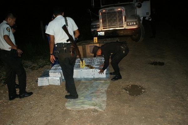 Autoridades ordenan las cajas que contienen cigarros de contrabando decomisados, en Santa Ana, Petén. (Foto Prensa Libre: Rigoberto Escobar) <br _mce_bogus="1"/>