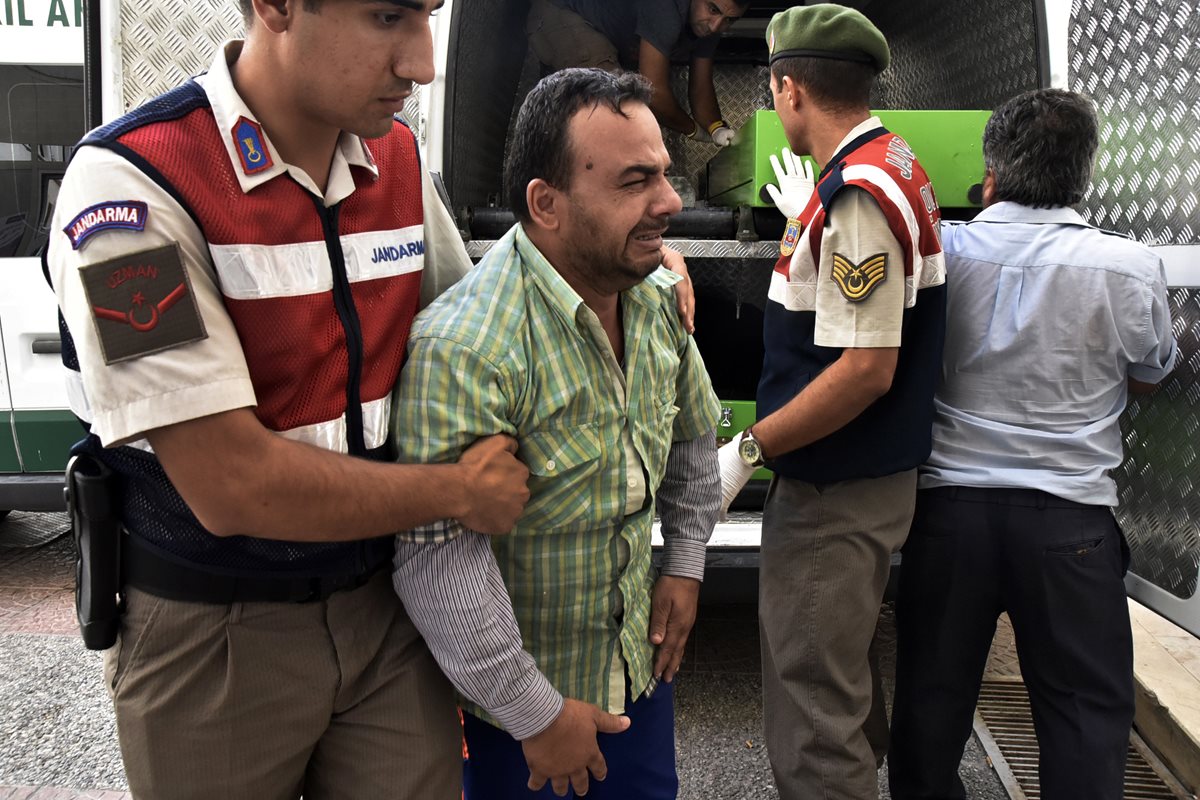 Hayat Sabir Burhan, sobreviviente sirio del naufragio, es consolado por agentes de la Policía turca después que perdió a su esposa, Ahlan, de 32 años y su hijo, Yusuf, de 3.Ahlan, 32. (Foto Prensa Libre: AP)