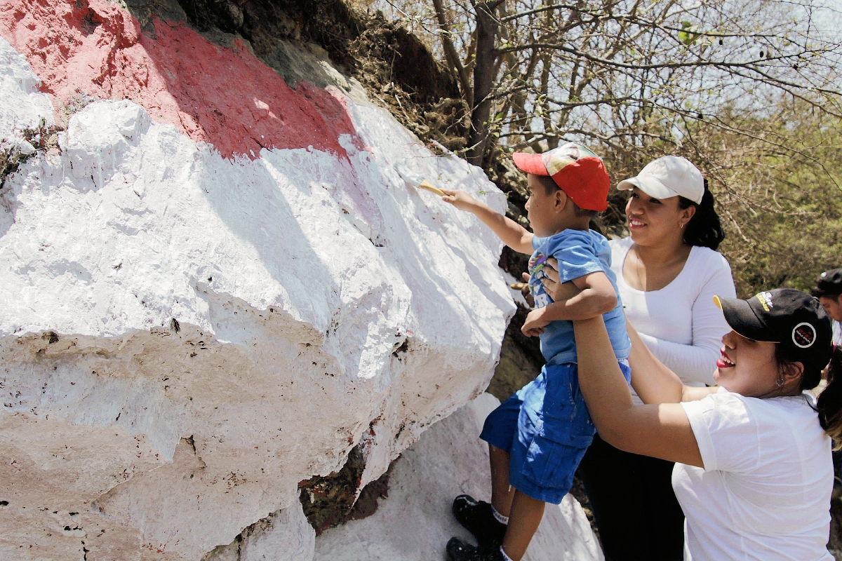 Una familia pinta de blanco piedras en la cabecera de Baja Verapaz, como muestra de rechazo a las pintas de partidos políticos. (Foto Prensa Libre: Carlos Grave)