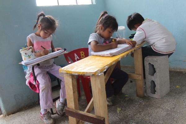 Niños de preprimaria de la escuela El Eucalipto, El Tejar, deben sentarse en blocks.