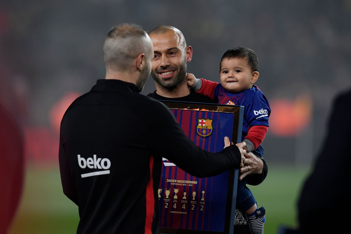 Javier Mascherano con su pequeño hijo en brazos recibe un reconocimiento de Andrés Iniesta antes de que iniciara el partido de Copa del Rey. (Foto Prensa Libre: AFP)