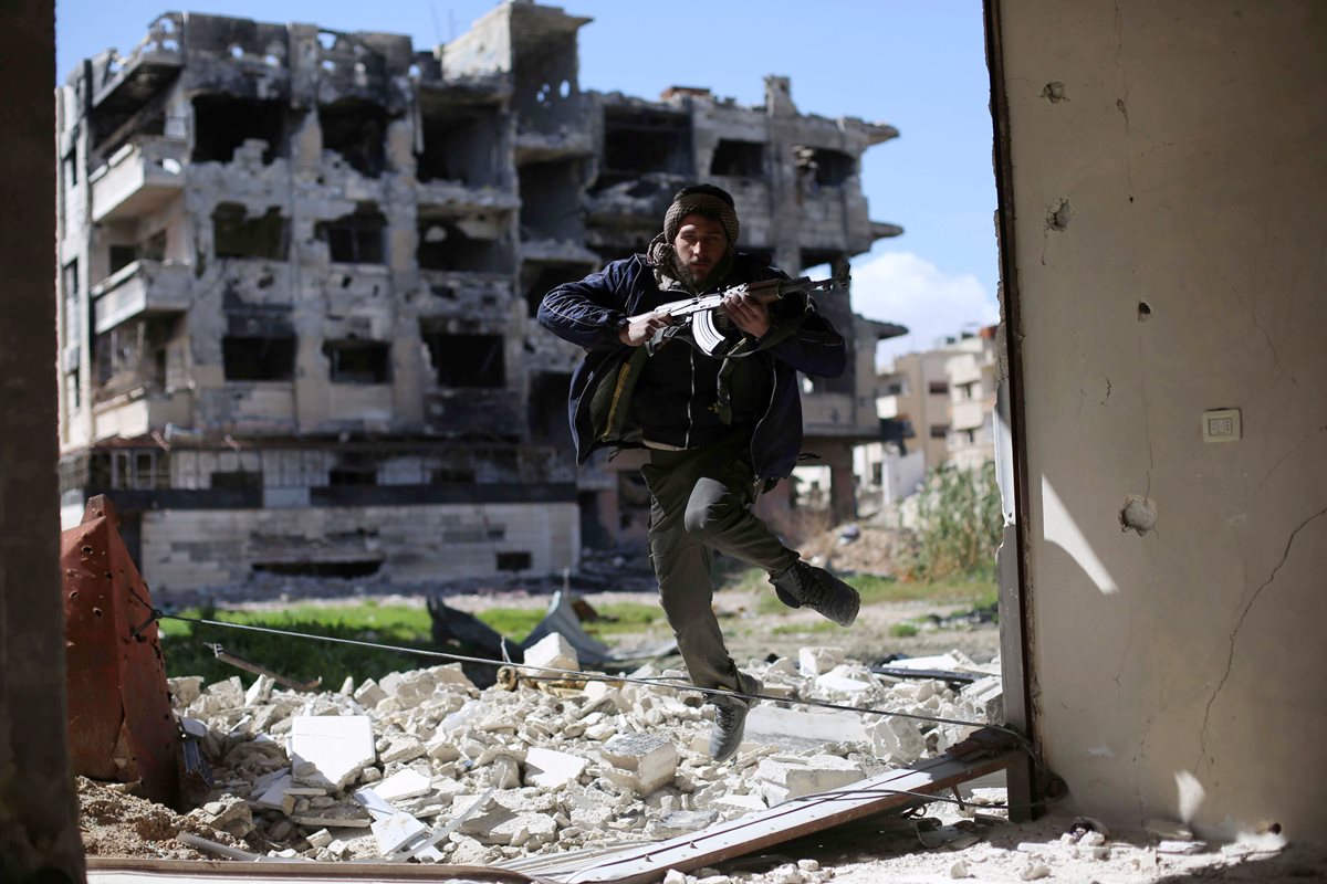 Un combatiente rebelde trata de ponerse a salvo durante un enfrentamiento en las afueras de Damasco, Siria. (Foto Prensa Libre: AFP).