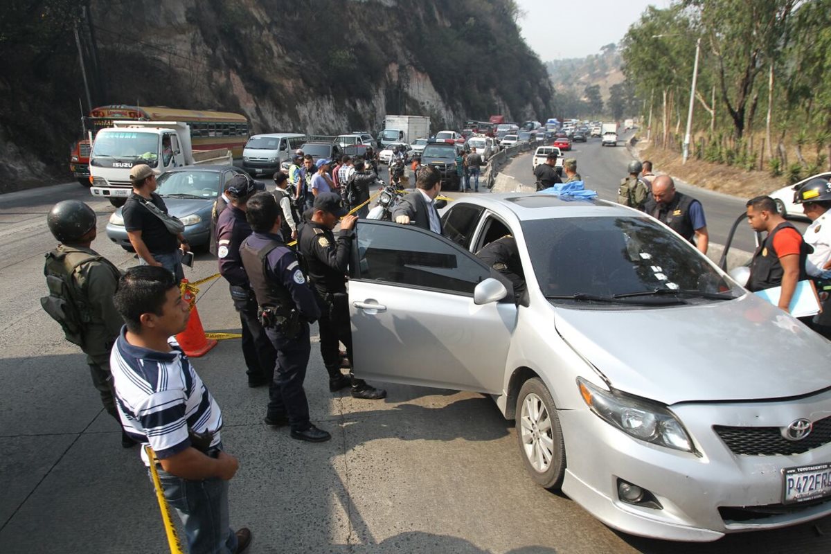 Autoridades inspeccionan el automotor donde viajaba la víctima, en la cuesta Villalobos. (Foto Prensa Libre: Érick Avila)