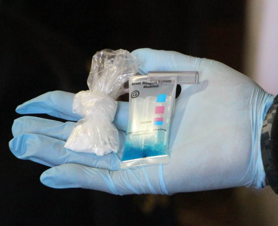 Un agente muestra parte de lo incautado en viviendas de la zona 3 de Zacapa. (Foto Prensa Libre: PNC)