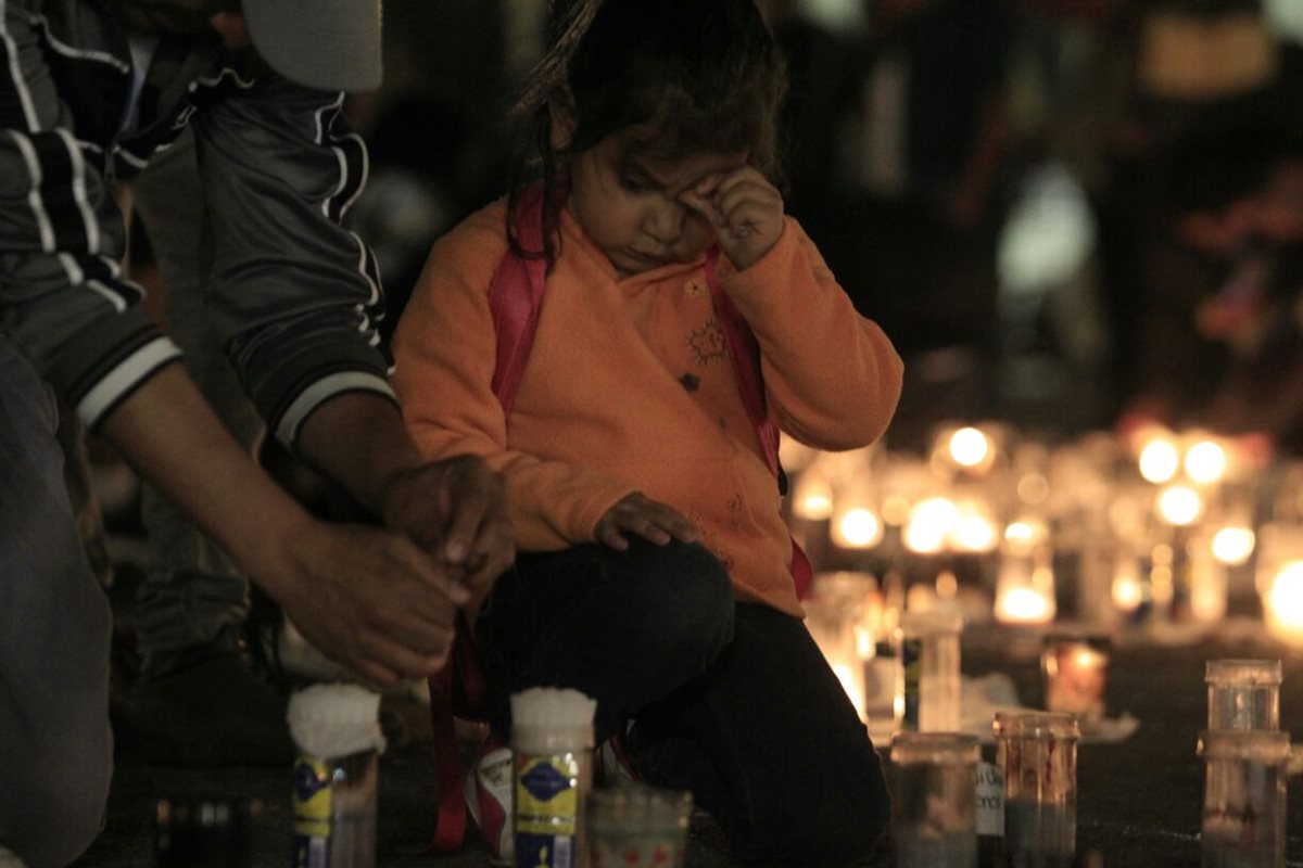 Una niña acompaña a su padre en la Plaza de la Constitución, donde ciudadanos demandan justicia por las muertes en el Hogar Seguro. (Foto Prensa Libre: Carlos Hernández.