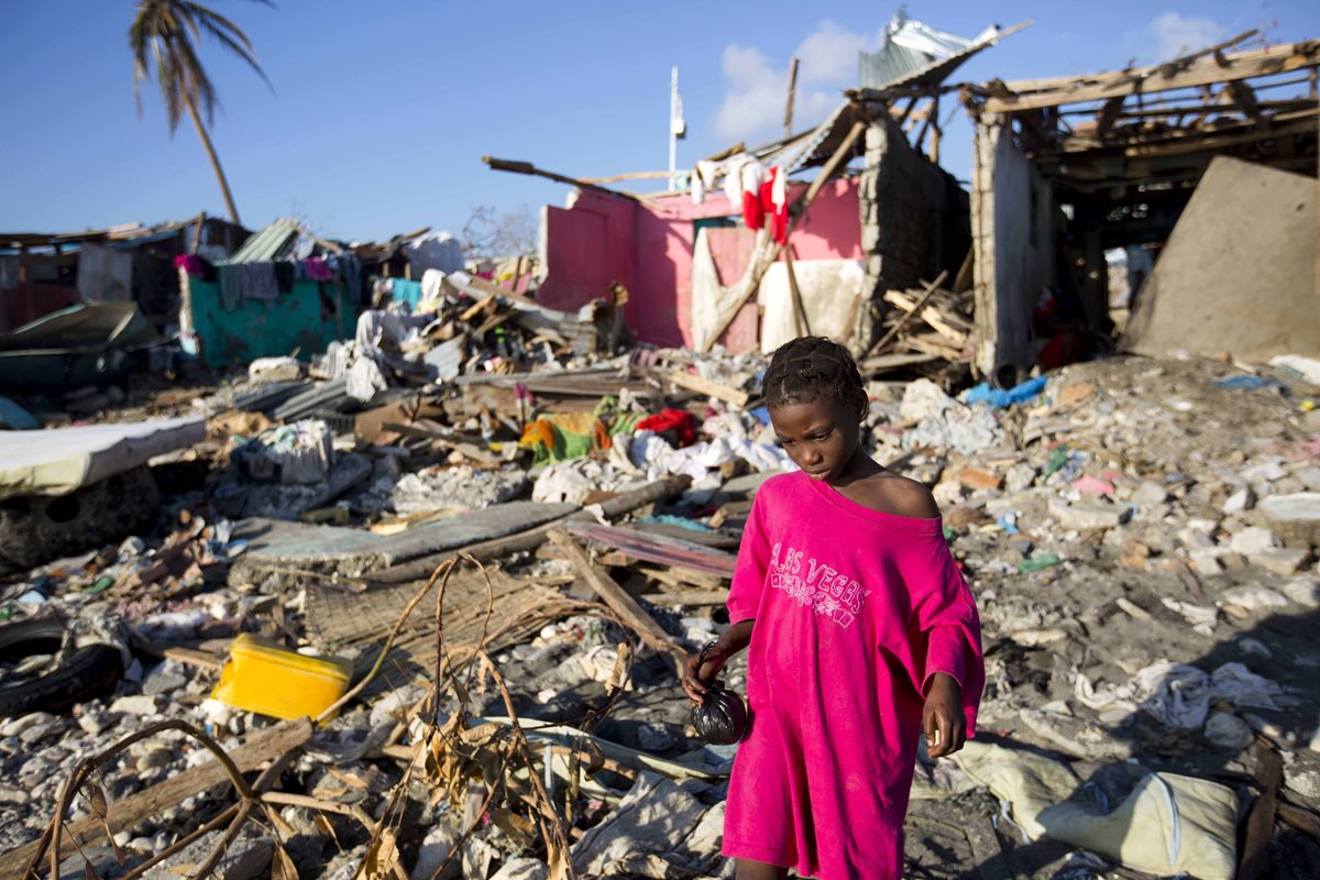 Una niña camina entre los escombros en Haití, luego del paso del devastador huracán Matthew en octubre del 2016. (Foto Prensa Libre: AP).