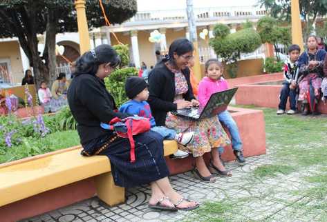 Mujeres utilizan el sistema  gratuito inalámbrico de internet en el parque central.