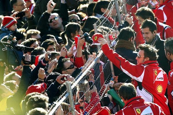 El piloto español saludó y firmó varios artículos de la marca Ferrari a cientos de seguidores. (Foto Prensa Libre: AFP)