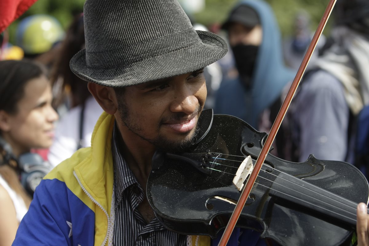 Wuilly Arteaga desafía a las fuerzas bolivarianas con su violín, con la finalidad de llamar a la paz. (Foto Prensa Libre: AP)