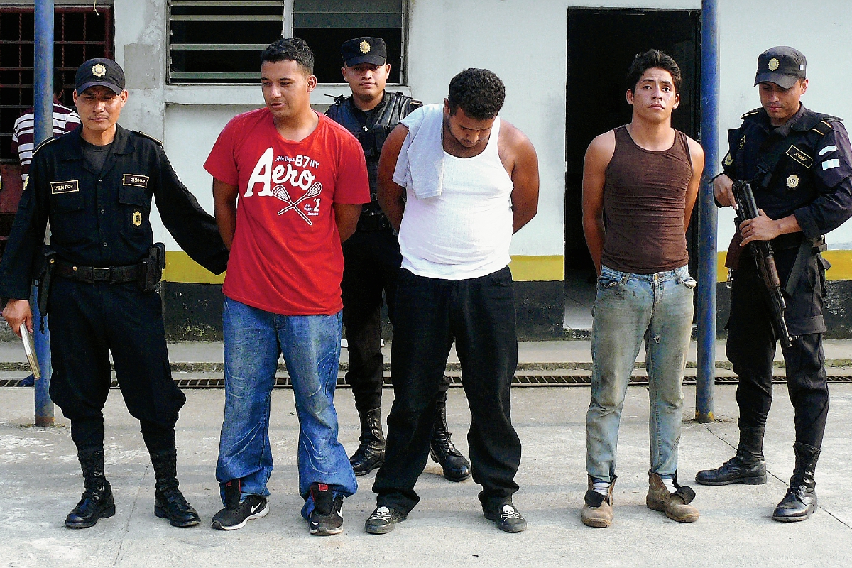 Los capturados en Santo Tomás de Castilla, Puerto Barrios, Izabal, son custodiados por agentes de la PNC. (Foto Prensa Libre: Edwin Perdomo)