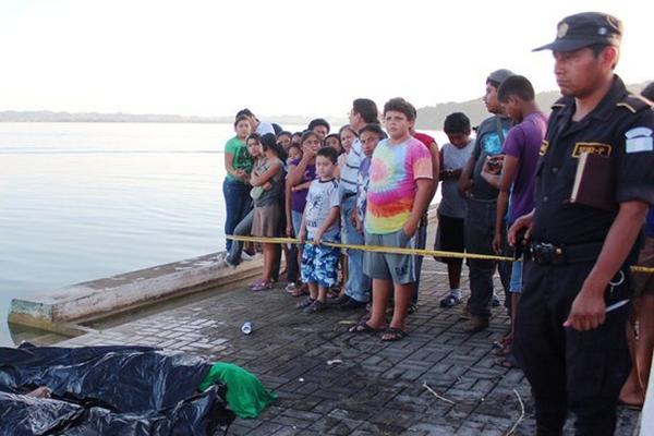 Curiosos observan los cadáveres de los dos primos que se ahogaron en el lago Petén Itzá, en San José. (Foto Prensa Libre: Rigoberto Escobar) <br _mce_bogus="1"/>