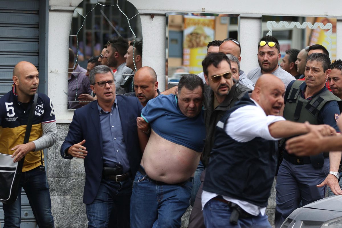 La Policía detuvo a un sospechoso (vestido de azul), tras el ataque armado. (Foto Prensa Libre: EFE).