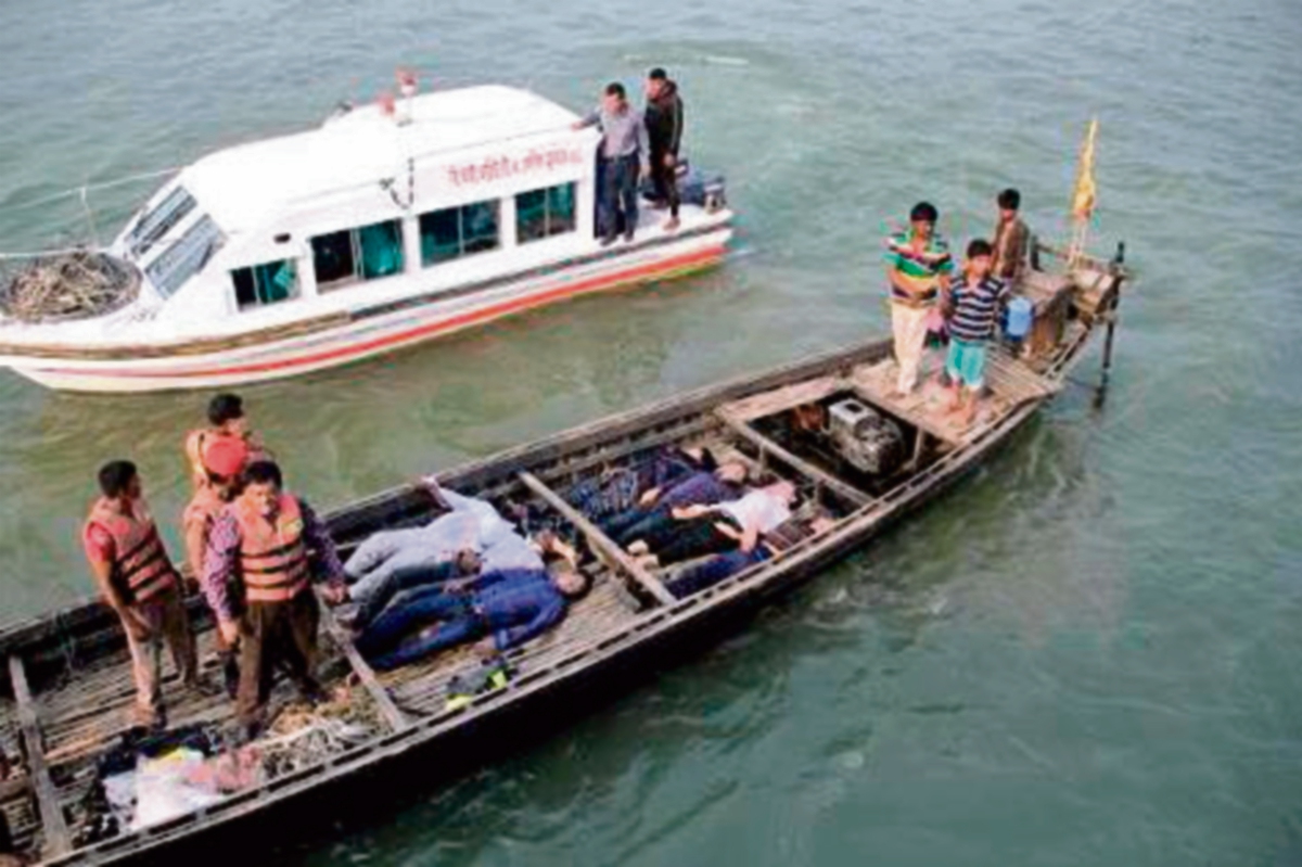 Oficiales bengalíes  cargan cuerpos de víctimas del naufragio de un ferry de pasajeros en Manikganj. AFP