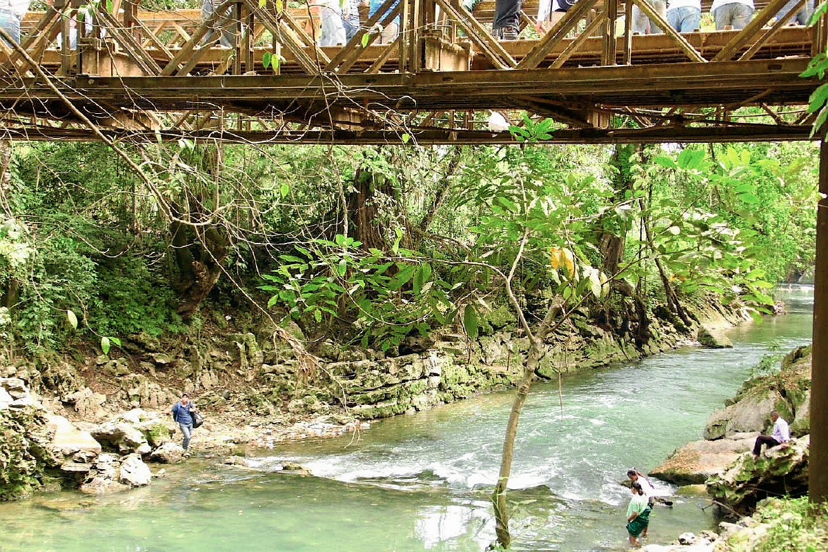 Pobladores de  Raxruhá y Fray Bartolomé de las Casas, Alta Verapaz, cruzan el río San Simón a pie, por bloqueo de puente. (Foto Prensa Libre: Facebook)