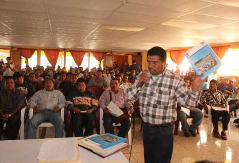 Gaspar Antonio, delegado de la aldea Nueva Generación Maya, muestra el informe de consulta comunitaria sobre minería.