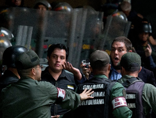 Dos legisladores de oposición discuten con los oficiales de la Guardia Nacional en la seda del CNE.(AFP)