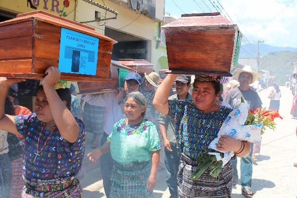 familiares  cargan féretros  para trasladarlos a  las comunidades de Rabinal.