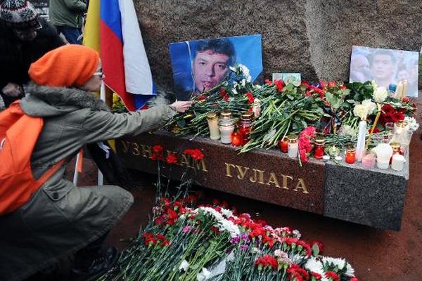 Una mujer cocloca unas flores en memoria del líder opositor ruso Boris  Nemtsov en la Piedra de Solovetski, en Rusia. (Foto Prensa Libre. AFP)