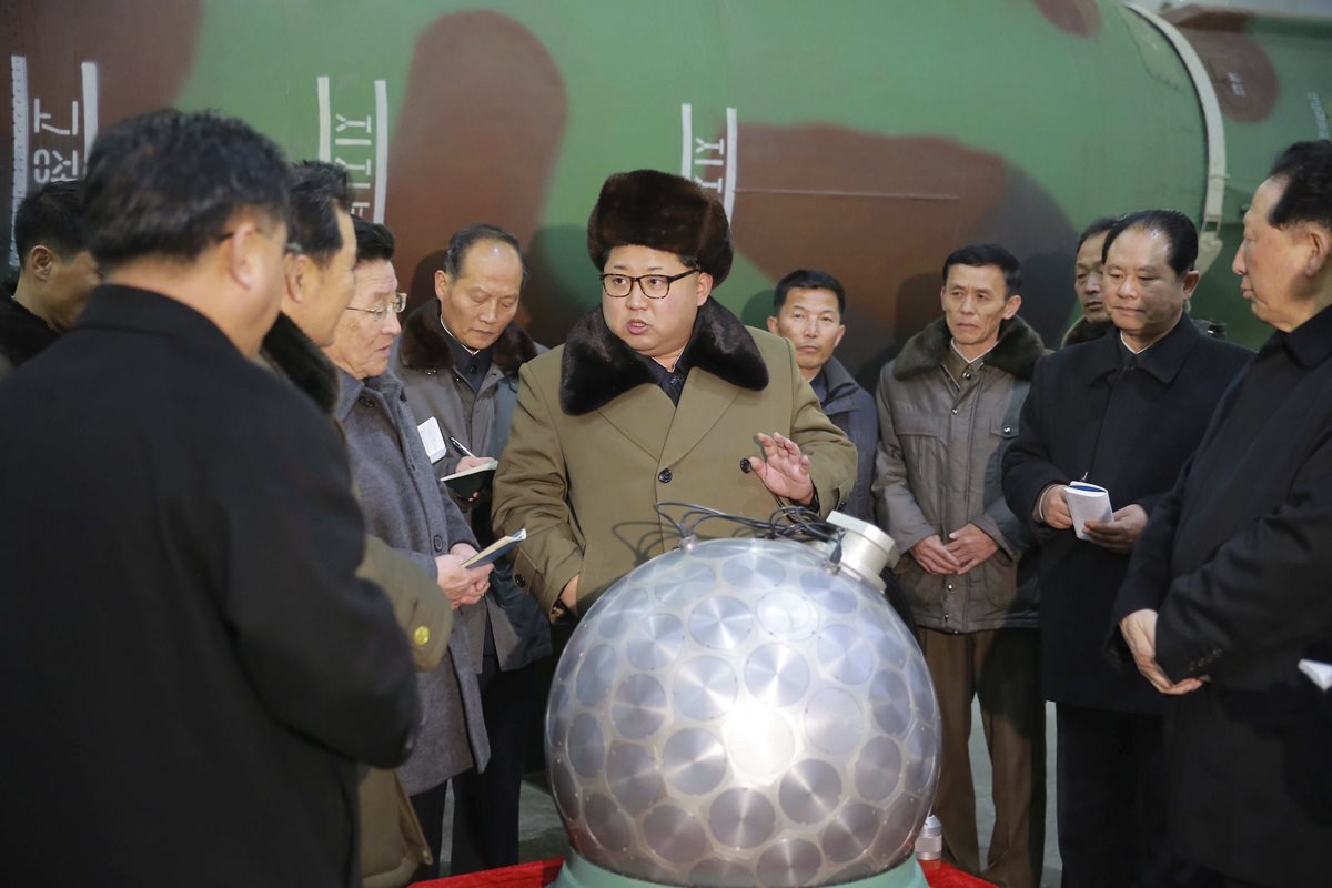 El líder de Corea del Norte, (centro) Kim Jong-un, conversa con los ingenieros y científicos del programa nuclear. (Foto Prensa Libre: EFE).