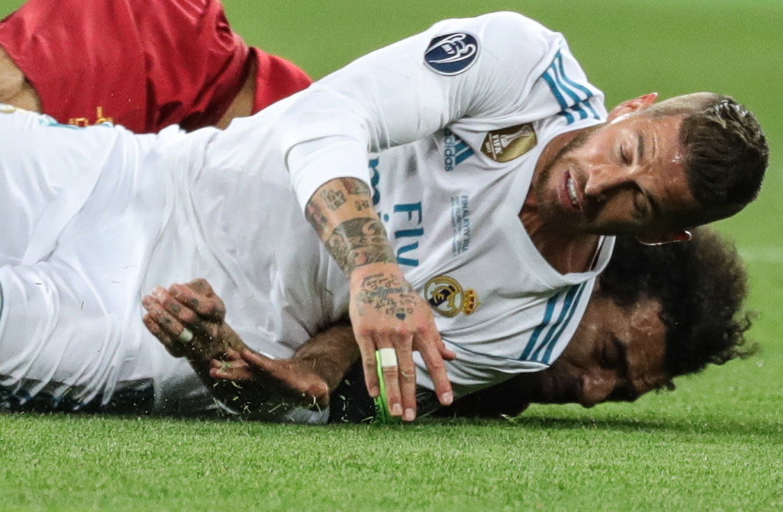 Sergio Ramos y Mohamed Salah, durante la acción que terminó en la lesión del egipcio. (Foto Prensa Libre: EFE)