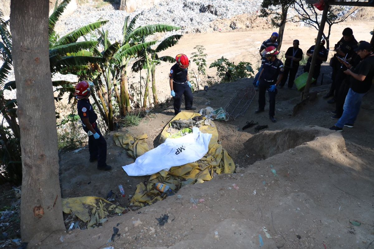 Socorristas rescatan el cuerpo de un PMT desaparecido en abril pasado en un deslizamiento en el relleno sanitaro. (Foto Prensa Libre: Estuardo Paredes)