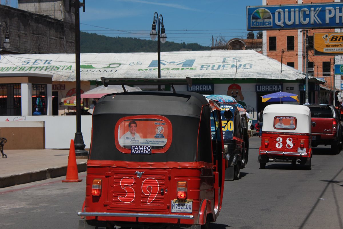 Unidades colectivas circulan en el parque central de Totonicapán con propaganda de Miguel Chavaloc, alcalde de la cabecera, quien busca la reelección. (Foto Prensa Libre: Lucero Sapalú)