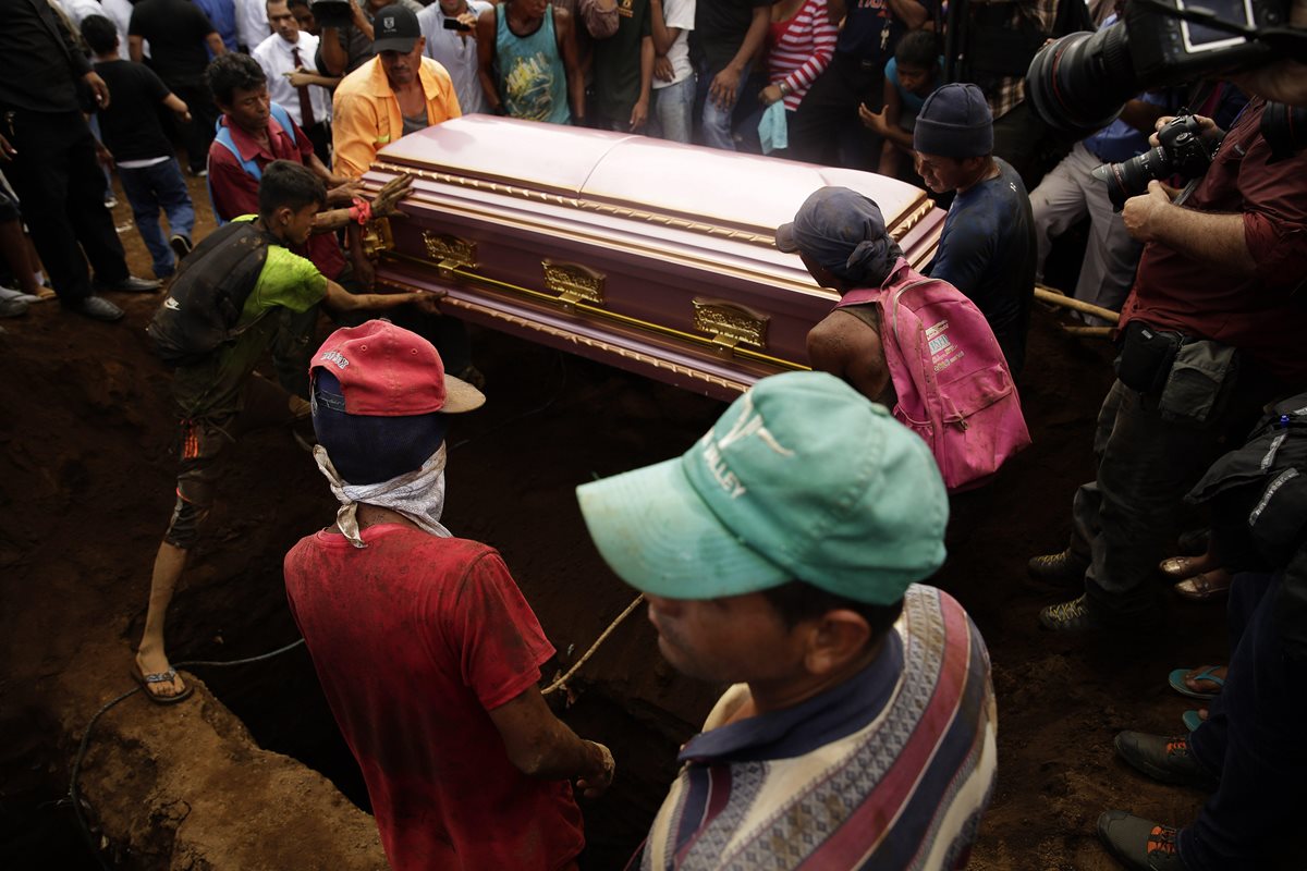 Varios nicaragüenses ayudan a sostener el féretro de una de las víctimas de la familia que murió ayer calcinada de Managua, Nicaragua. (Foto Prensa Libre:EFE).