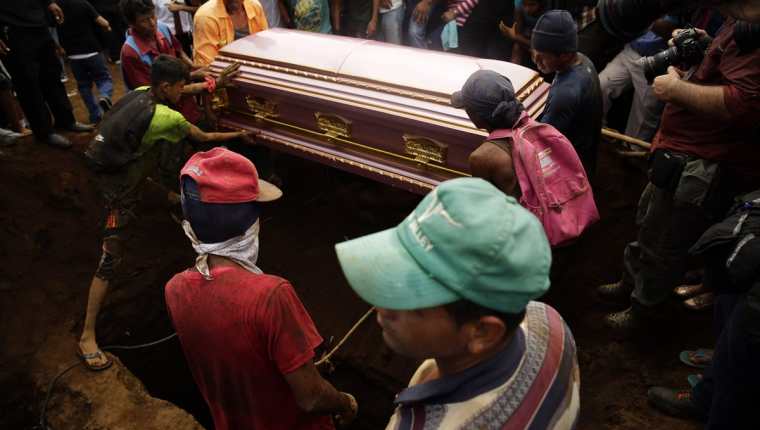 Varios nicaragüenses ayudan a sostener el féretro de una de las víctimas de la familia que murió ayer calcinada de Managua, Nicaragua. (Foto Prensa Libre:EFE).