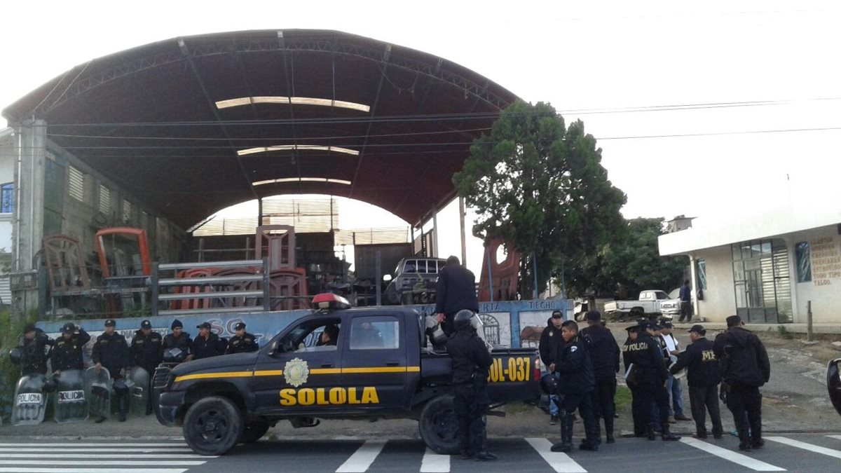 Agentes de la PNC acordonan taller de mecánica en Sololá, donde se efectuaron los allanamientos. (Foto Prensa Libre: PNC)