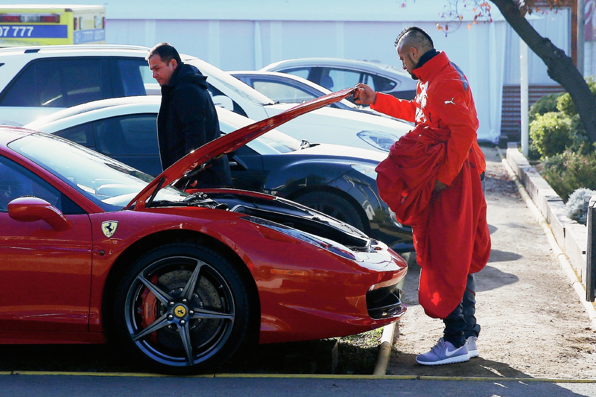 Arturo Vidal revisa su auto Ferrari ayer a la legada al entrenamiento matutino del equipo en el complejo deportivo Juan Pinto Durán. (Foto Prensa Libre: EFE)