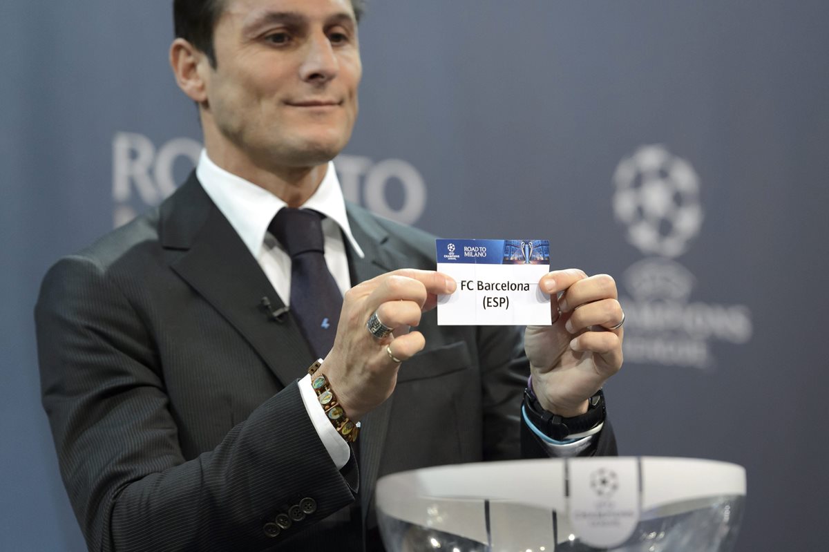 El exfutbolista argentino Javier Zanetti sostiene la papeleta del FC Barcelona que se enfrentará al Arsenal en los octavos de final de la Champions.(Foto Prensa Libre: EFE)