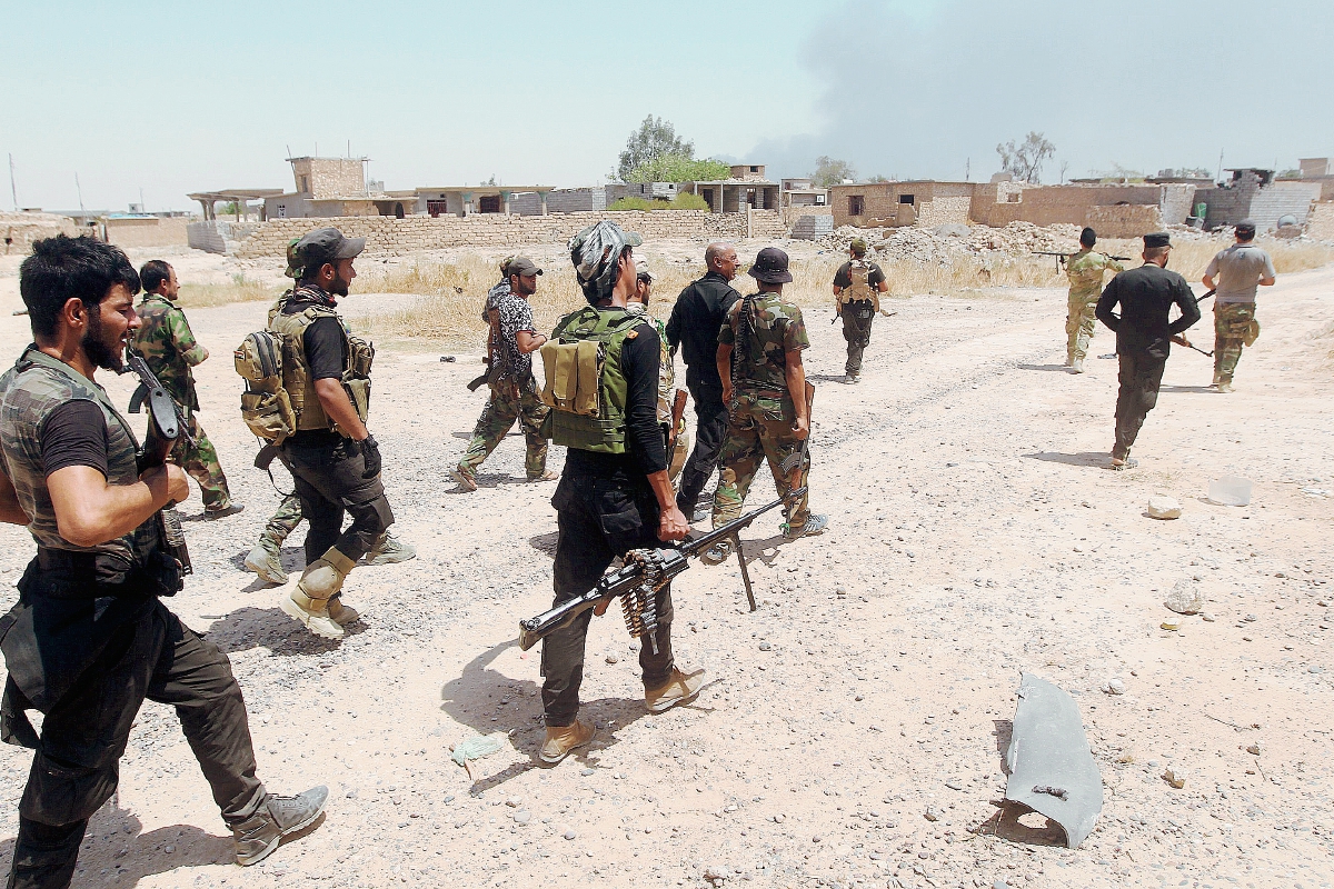 Combatientes iraquíes se movilizan en las afueras de la refinería de Baiji al norte de Tikrit. (Foto prensa Libre:AFP).
