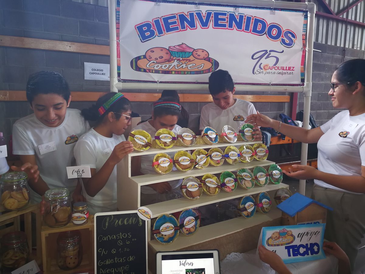 Grupo de estudiantes del Colegio Capoulliez exhiben parte de sus productos que impulsan en su emprendimiento. (Foto Prensa Libre: Oscar García).