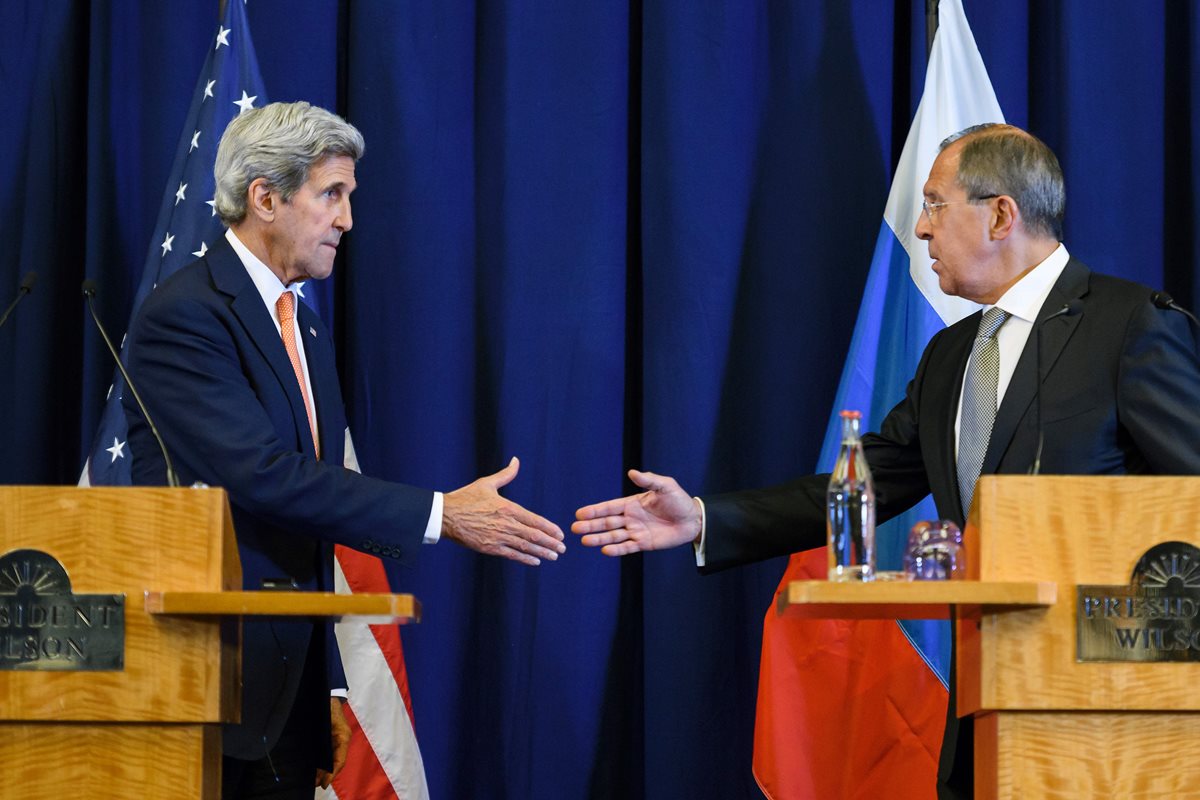 El secretario de Estado estadounidense, John Kerry (izq.) estrecha la mano del canciller ruso, Sergei Lavrov, en Ginebra. (Foto Prensa Libre: AFP).