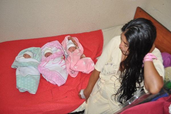 Madre observa a sus tres pequeñas hijas, en el Hospital Regional de  Huehuetenango.