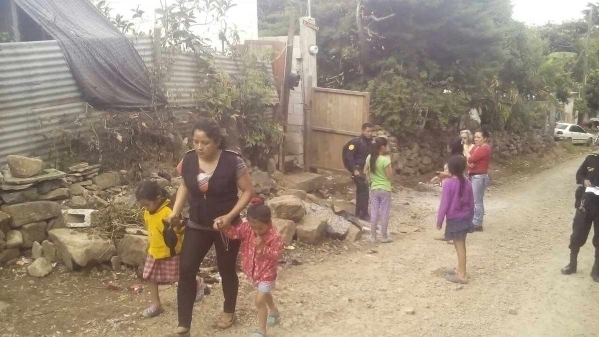 Una agente de la PNC acompaña a las niñas luego de ser encontradas en abandono en Palencia, Guatemala. (Foto Prensa Libre: Cortesía)