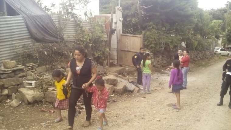 Una agente de la PNC acompaña a las niñas luego de ser encontradas en abandono en Palencia, Guatemala. (Foto Prensa Libre: Cortesía)