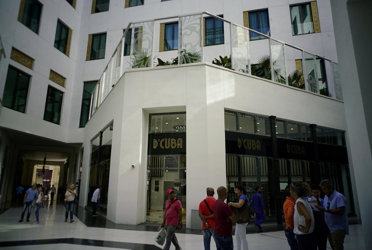 Personas admiran el frente de las tiendas del centro comercial ubicado en la Habana, Cuba. (Foto Prensa Libre: AP)
