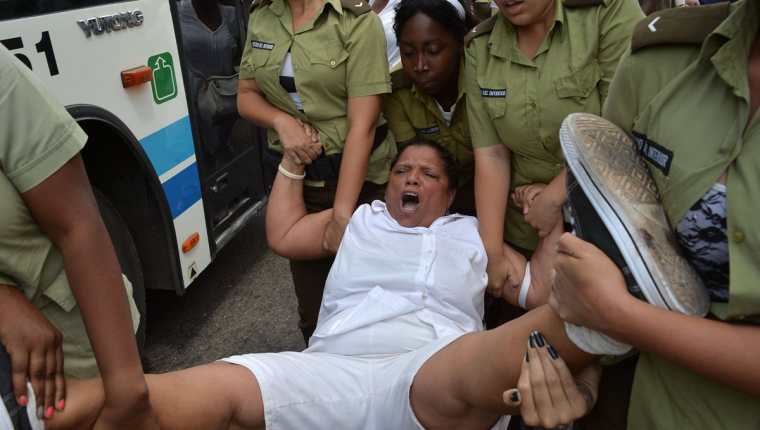 Una integrantes de las Damas de Blanco es detenida por la Policía. (Foto Prensa Libre: AFP)
