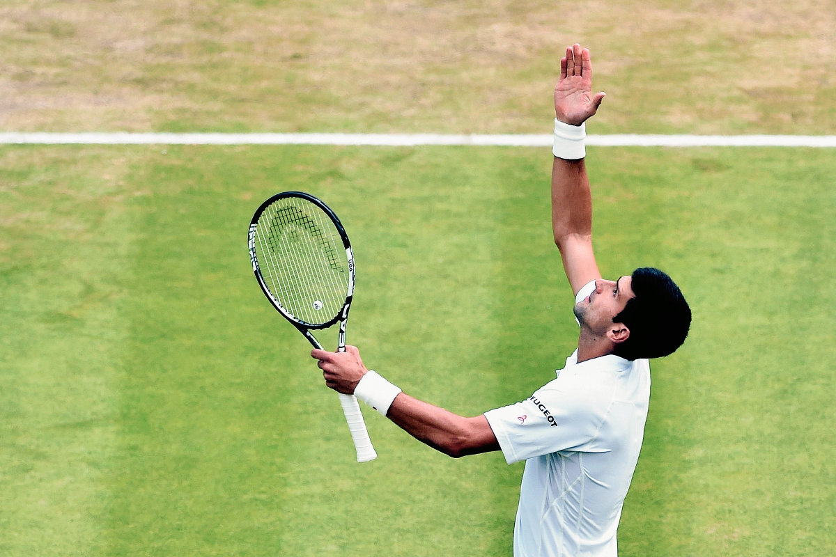 Novak Djokovic extiende los brazos en señal de triunfo luego de avanzar a los cuartos de final de Wimbledon. (Foto Prensa Libre: AFP)