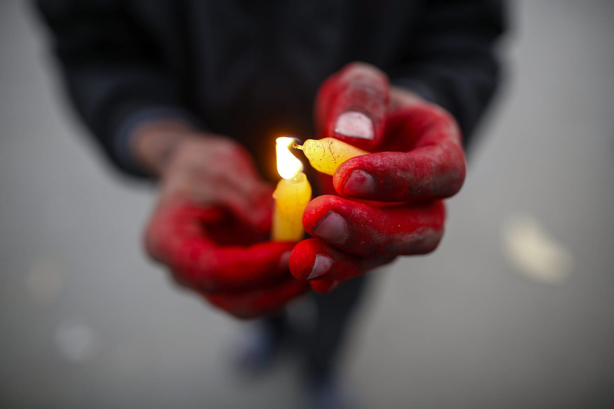Un niño nepalí enciende una vela en el acto dedicado a aquellos que han perdido la vida a causa de esta enfermedad. (Foto Prensa Libre: EFE).