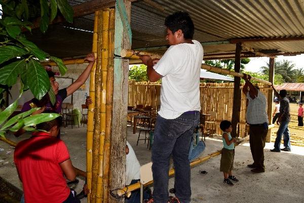 Graduandos, con ayuda de vecinos, laboran en edificación de aula para escuela de Sayaxché.